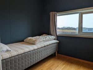 a bed in a room with a window at Green appartement in Sandnes