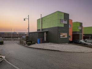 a building in a parking lot with cars parked outside at Green appartement in Sandnes