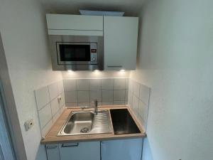 a small kitchen with a sink and a microwave at Ferienwohnung Schlossblick in Heiligenstadt