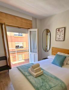 a bedroom with a bed with a mirror and a window at Feeling Home Lope de Fenar in León