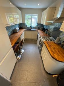 a kitchen with white cabinets and wooden counter tops at The Palms Brighton in Brighton & Hove