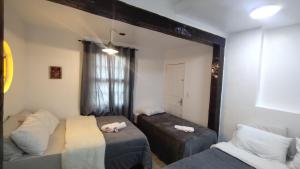 a room with two beds and a mirror at Suíte Master conforto e espaço vizinha do Palácio de Cristal! in Petrópolis