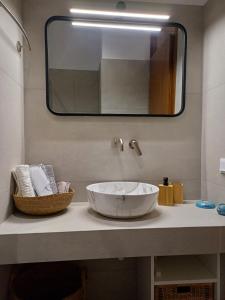 a bathroom with a large white sink and a mirror at aerie home Skyros in Skiros +21 photos