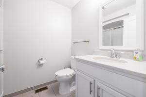un bagno bianco con un water e un lavandino di Luxury Downtown Townhome Unit 5 a Cleveland Altre 32 foto