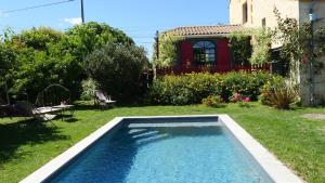 a swimming pool in the yard of a house at La chambre des jardins d'Ispahan in Prignac-et-Marcamps