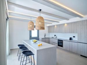 Villa Sol Cielo Naousa Paros في ناوسا: مطبخ فيه كونتر ابيض وبايات