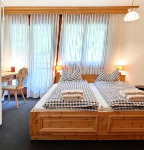two twin beds in a bedroom with a desk and window at Schöne Ferienwohnung im Zentrum von St. Moritz in St. Moritz
