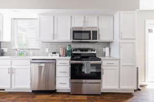 a white kitchen with a stove and a microwave at Luxury Downtown Townhome Unit 13 in Cleveland