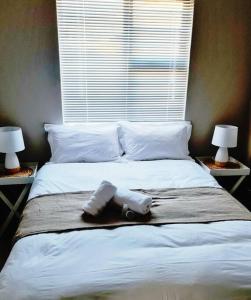 ein Bett mit zwei Handtüchern und zwei Lampen drauf in der Unterkunft Cheerful 3-bedroom vacation home in Kathu