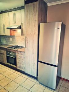 eine Küche mit einem weißen Kühlschrank und einem Herd in der Unterkunft Cheerful 3-bedroom vacation home in Kathu