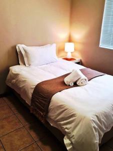 ein Schlafzimmer mit einem Bett, auf dem ein Stofftier liegt in der Unterkunft Cheerful 3-bedroom vacation home in Kathu