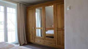 a wooden cabinet in a bedroom with a bed at Seeblick in Groß Schwansee