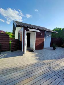 a house with a wooden deck with a door at Apartament TAM GDZIE ZAWSZE in Wałcz