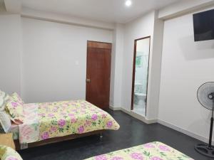 a bedroom with two beds and a mirror at Hospedaje Marfeb in Cieneguilla