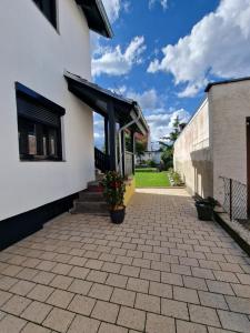 a white building with awning and potted plants on a patio at Safran Apartments Gunzburg in Günzburg