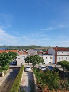 a parking lot with cars parked in front of buildings at Apartment Sidro in Posedarje