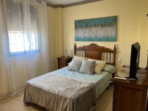 a bedroom with a bed with a television in it at Olas y Sol in Roquetas de Mar +45 photos
