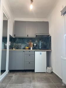 une cuisine avec des armoires blanches et un réfrigérateur blanc dans l'établissement Silvia, à Skala Sotiros