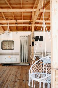 an rv parked in a room with a swing at Каравана Бохемия in Chernomorets
