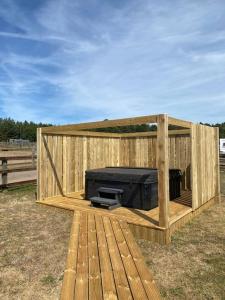 une structure en bois avec une télévision à l'intérieur dans l'établissement Barn Owl Lodge with Hot Tub - Adults Only, à Lackford 10 autres photos