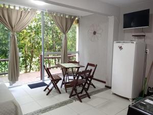 a kitchen with a table and chairs and a refrigerator at Flat Lugar dos Sonhos in Cairu