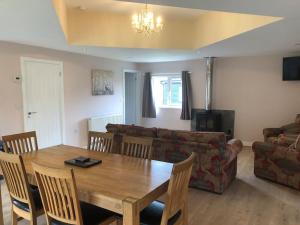 un salon avec une table en bois et un canapé dans l'établissement Barn Owl Lodge with Hot Tub - Adults Only, à Lackford