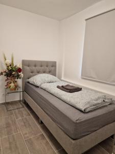 a bed in a white room with at Safran Apartments Gunzburg in Günzburg