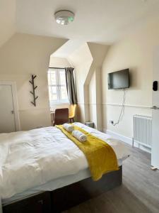 a bedroom with a bed with a yellow blanket on it at Edinburgh full house in Edinburgh