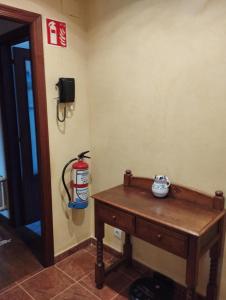 a room with a wooden table and a fire extinguisher at La Casa de Conchi in Comillas