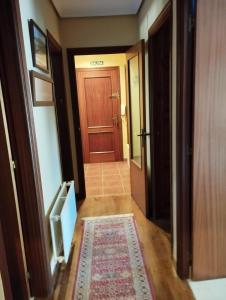 a hallway with a door and a rug in a room at La Casa de Conchi in Comillas