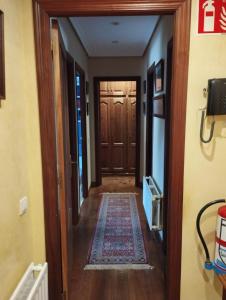 a hallway leading into a room with wooden doors at La Casa de Conchi in Comillas