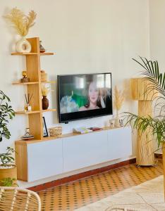 a living room with a flat screen tv on a white wall at mama appartement 2 in Essaouira