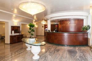 a lobby with a round glass table and a salon at Hotel Ambassador in Rimini +37 photos