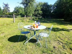 a table with chairs and fruit on it in a field at Peaceful studio in Coye-la-Forêt in Coye-la-Forêt