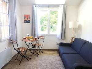 a living room with a blue couch and a table at Peaceful studio in Coye-la-Forêt in Coye-la-Forêt
