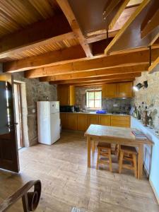 una cucina con un tavolo e un frigorifero bianco di Casa da iapa a Soajo Altre 4 foto