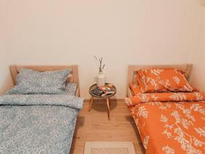 a bedroom with two beds and a table with a side table at Apartman Hači in Kolašin