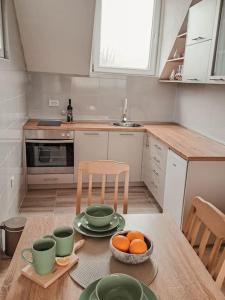 a kitchen with a table with a bowl of oranges on it at Apartman Hači in Kolašin