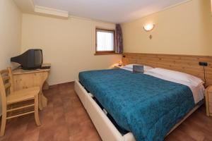 1 dormitorio con 1 cama grande y TV en Appartamento Levanto, en Livigno