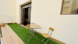 Una mesa y dos sillas en una habitación con césped en Khaliq Basera, en Dubái