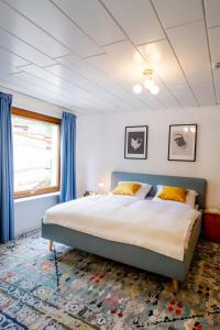 a bedroom with a large bed with blue curtains at birds-nest Ferienhaus Balkon Waldblick Kamin in Darstein