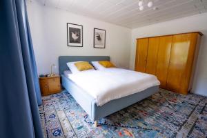 a bedroom with a bed and a wooden cabinet at birds-nest Ferienhaus Balkon Waldblick Kamin in Darstein