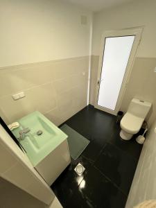 a bathroom with a white toilet and a sink at Ribeira Roots Residence in Santa Cruz +14 photos