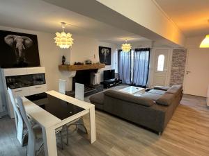 a living room with a couch and a table at Maison individuelle à 8 minutes d'Ouistreham, quartier calme, transports en commun Tram & Bus, commerces de proximités in Hérouville-Saint-Clair