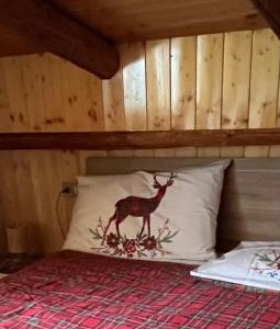 a bed with a pillow with a deer on it at Casa MB in Folgarida