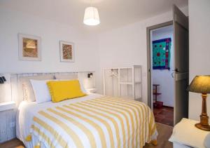 a bedroom with a yellow and white striped bed at Casa do Largo in Torres Vedras