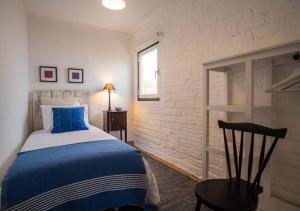 a bedroom with a blue and white bed and a chair at Casa do Largo in Torres Vedras