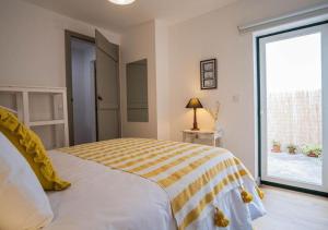 a bedroom with a yellow and white bed and a window at Casa do Largo in Torres Vedras
