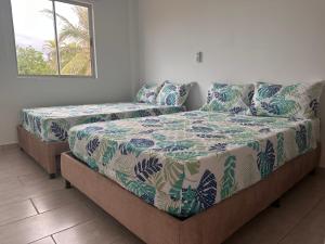 a bedroom with two beds and a couch at Casa 5 Brisa Piso 2- Palmar De Los Vientos in San Bernardo del Viento