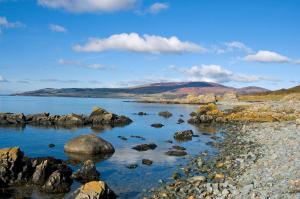 a body of water with rocks and mountains in the background at Charming Galloway cottage near Kirkcudbright in Twynholm